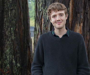 Nick Kalivoda standing outside in front of redwood trees