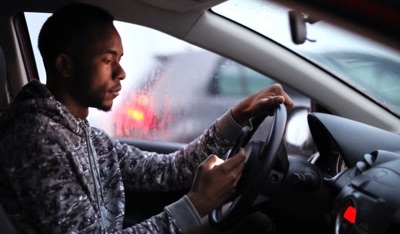 African man driving in the rain.