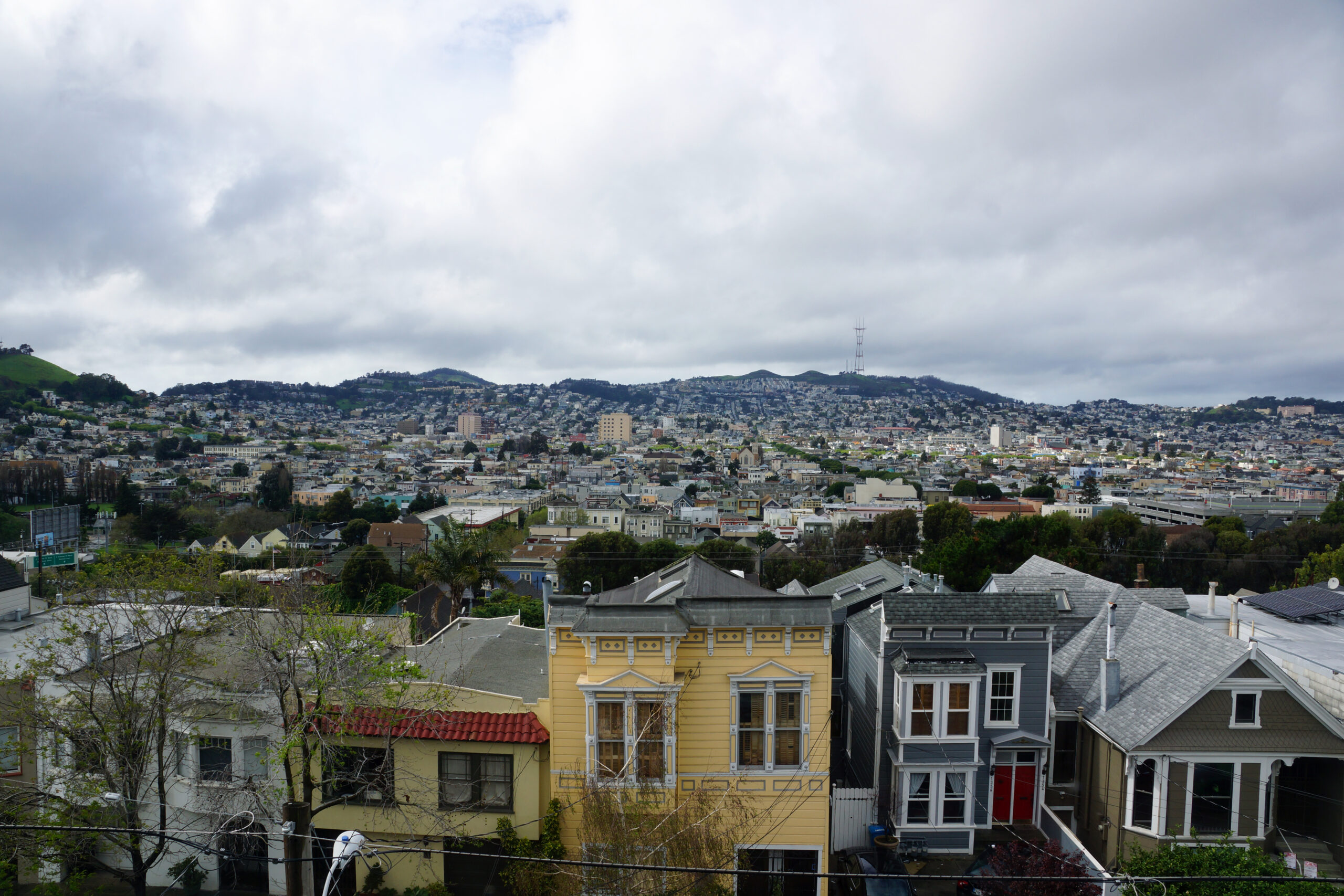 Aerial view of Houses, Cars. Cityscape, streets, and mountians of San Francisco in Potrero Hill Neighborhood with power-lines and cars parked on street.