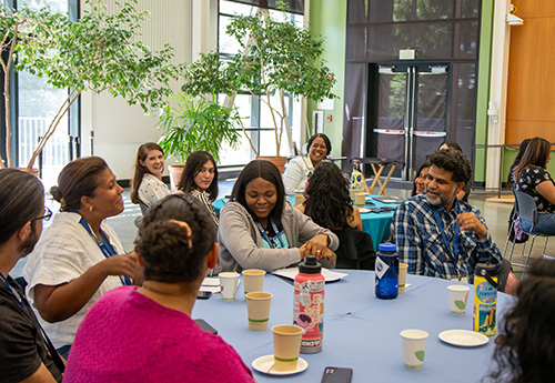 Conference participants talk around a round table.