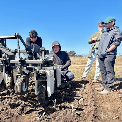 Students in a field with a farm robot