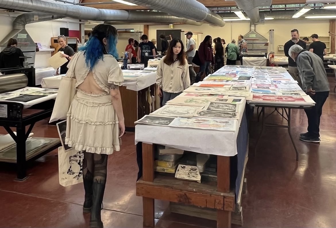 blue haired girls walks through annual print sale