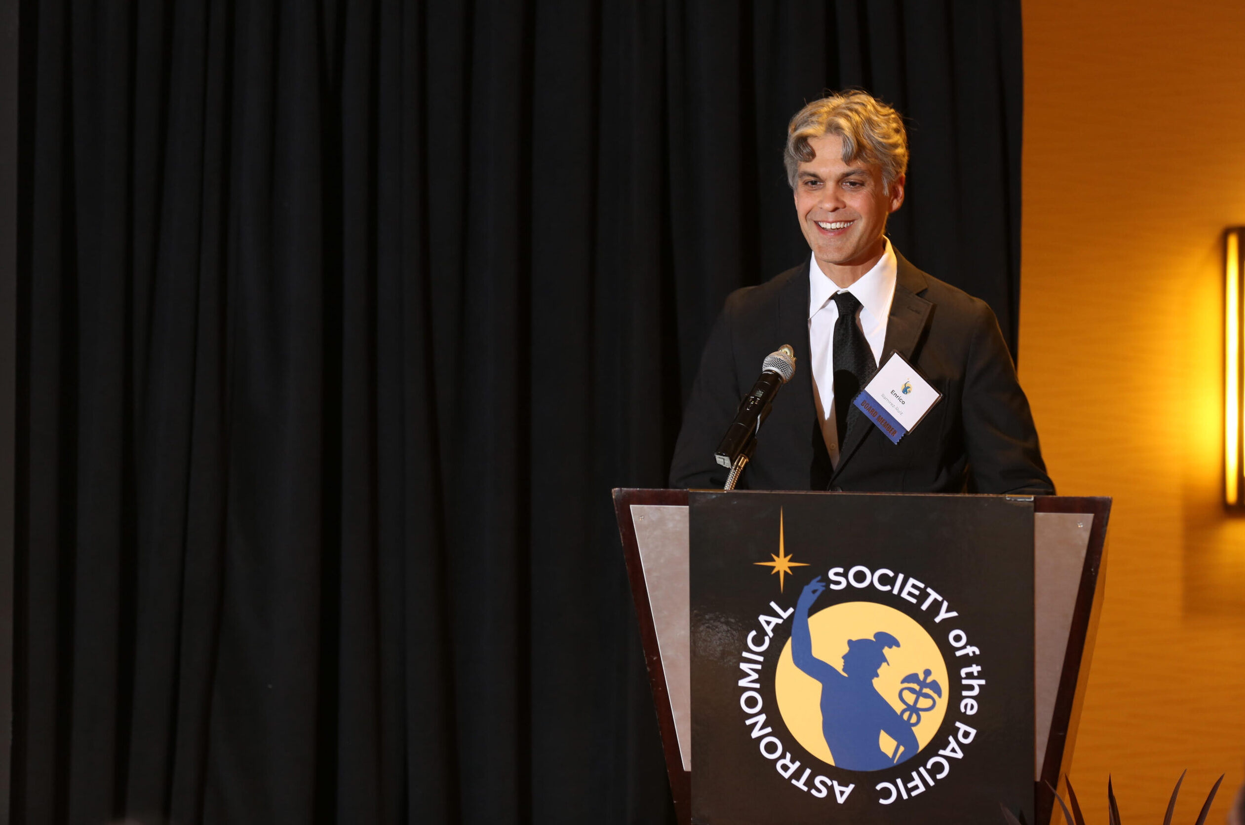 Enrico Ramirez-Ruiz behind lectern at ASP event.