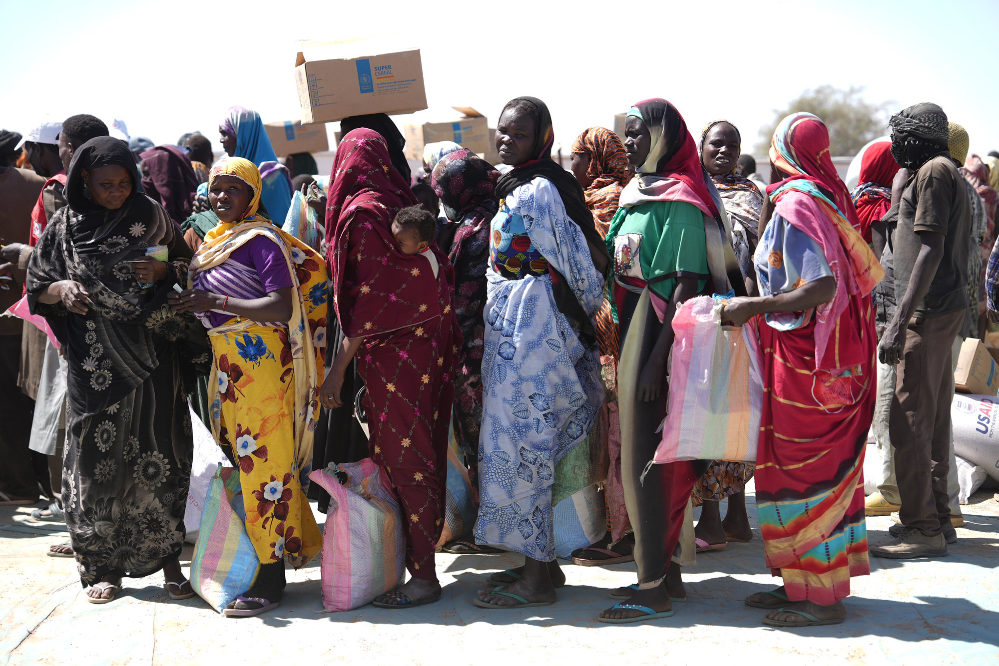Refugees stand in line to receive food aid
