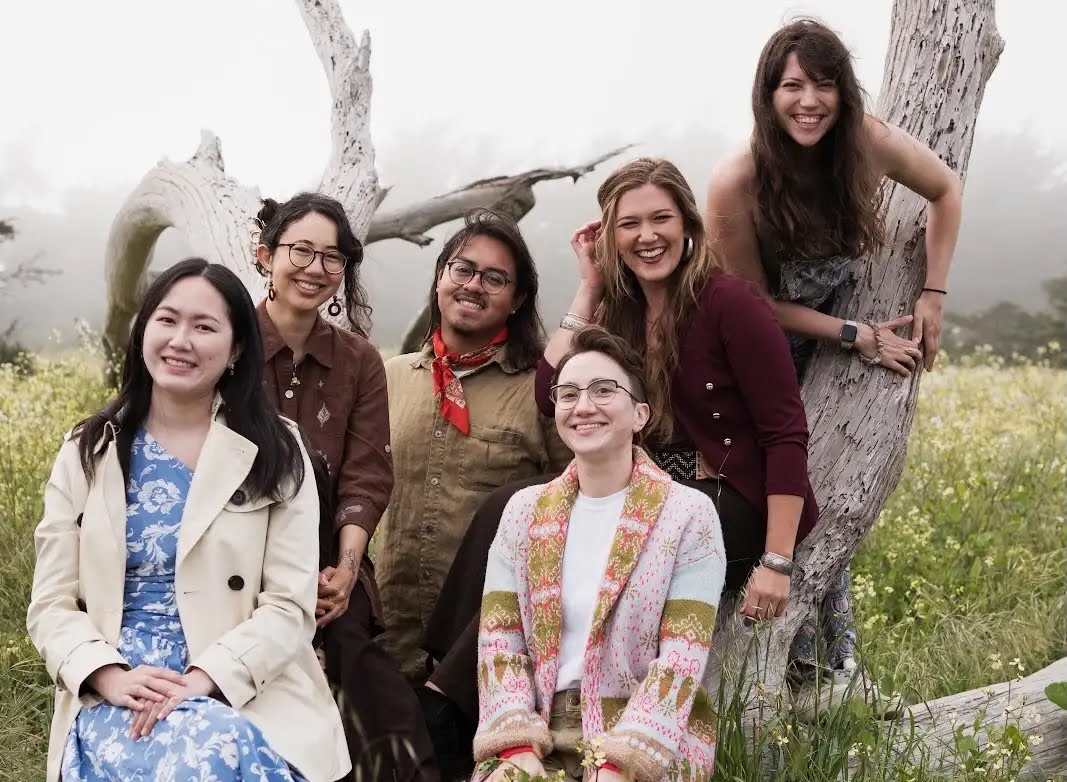 six graduate students posing on a tree