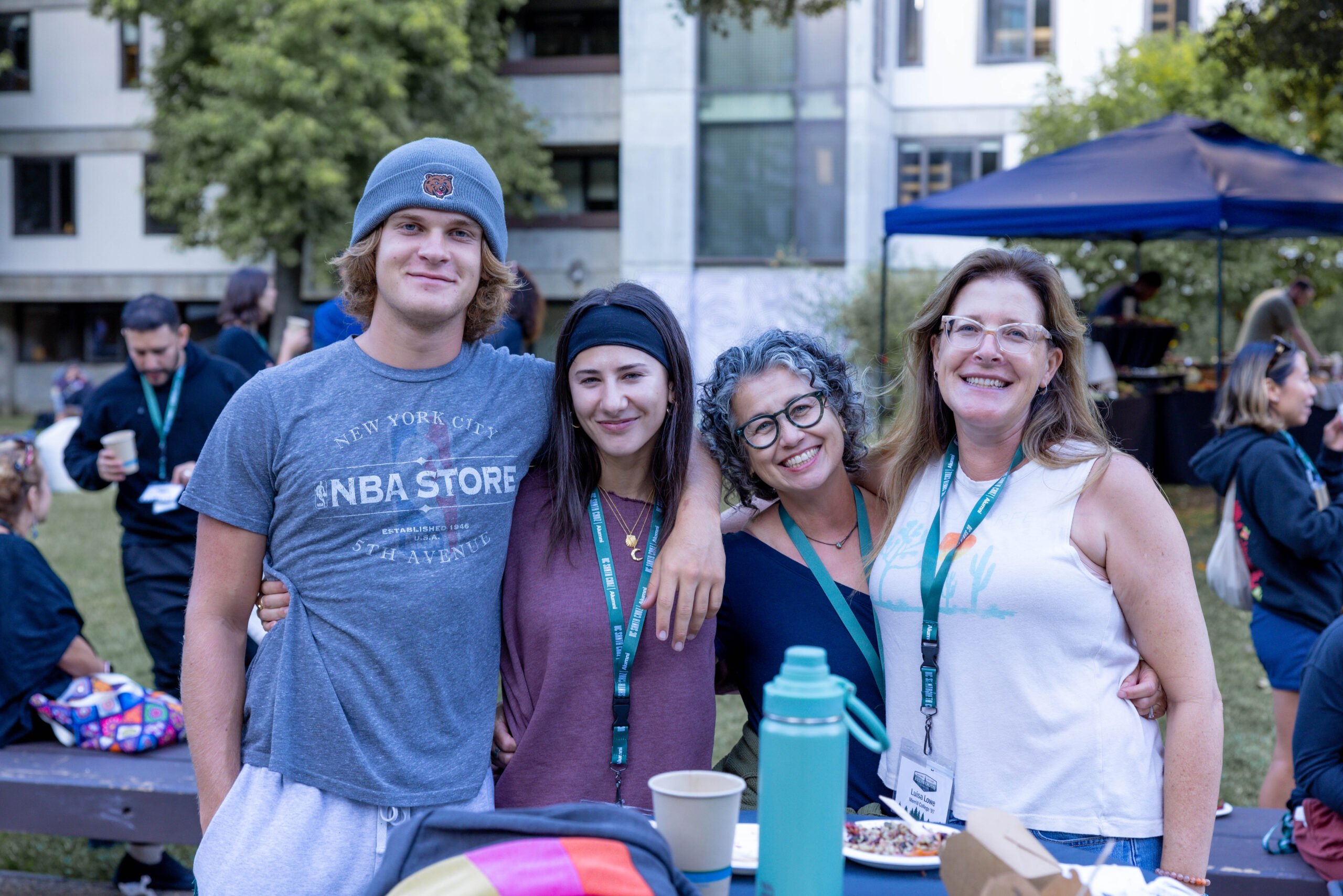 Four alumni pose for a photo in the Porter Quad