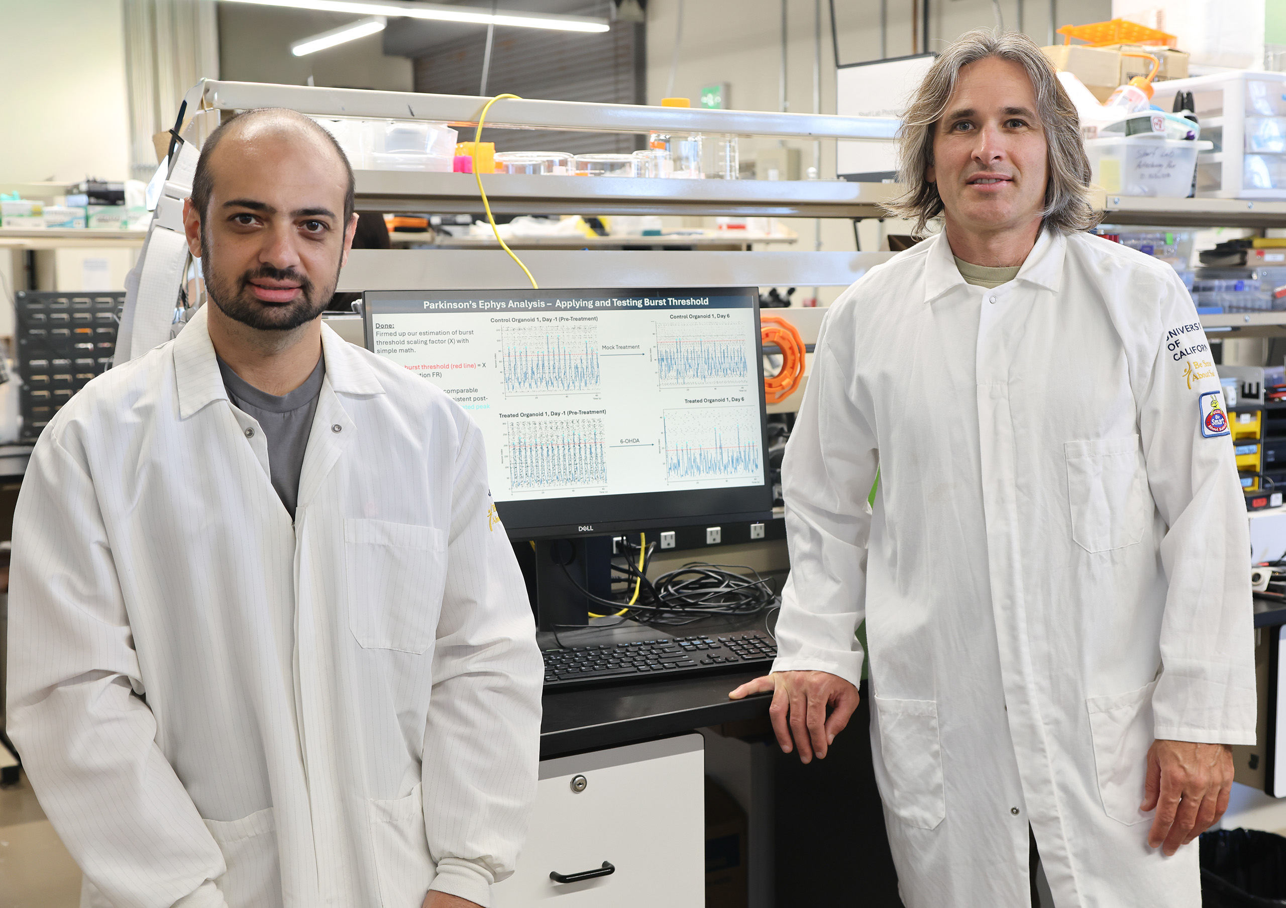 Mostajo Radji and Sharf stand in the lab with white lab coats.