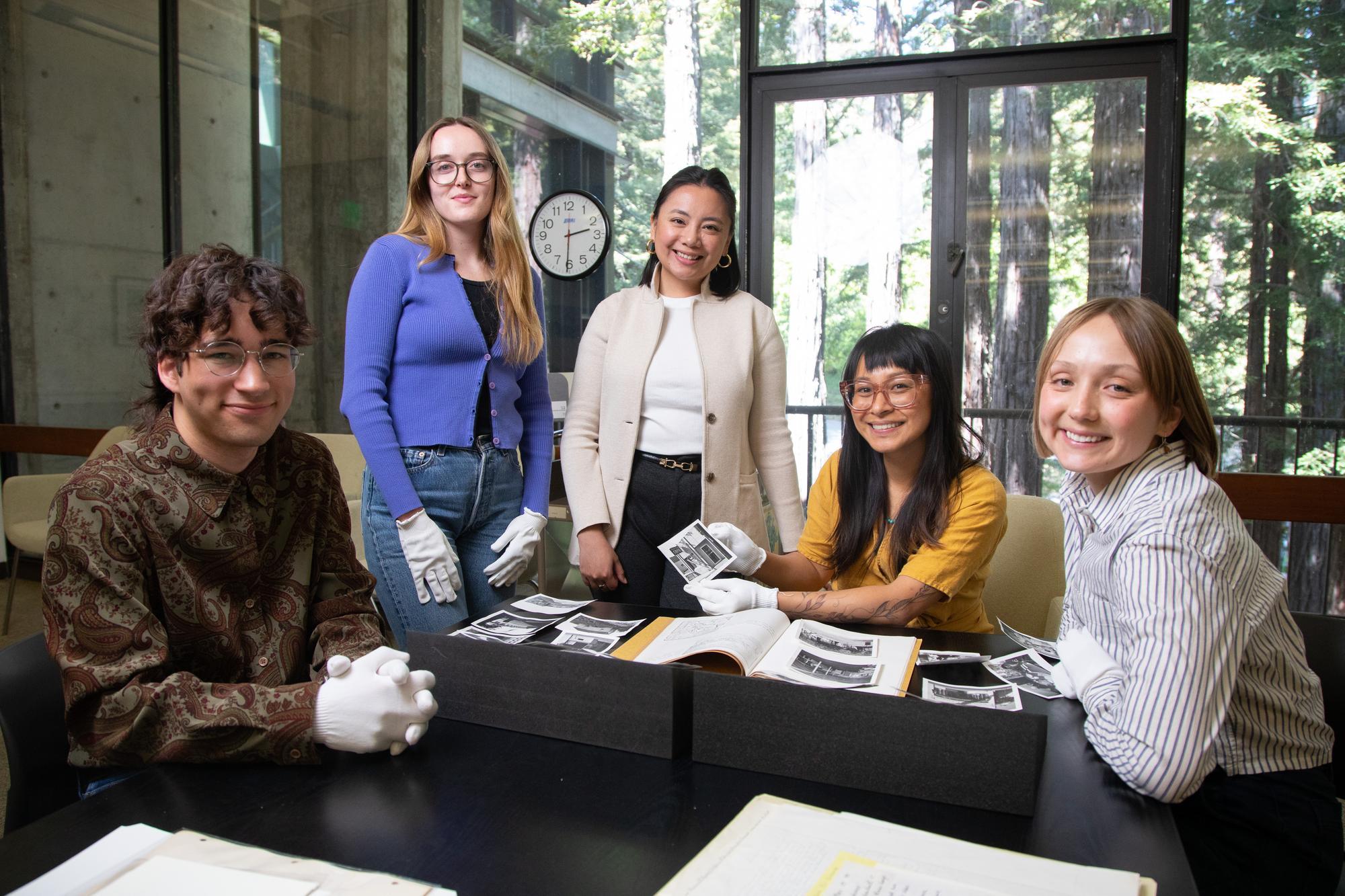 Students and a faculty member handle archival materials