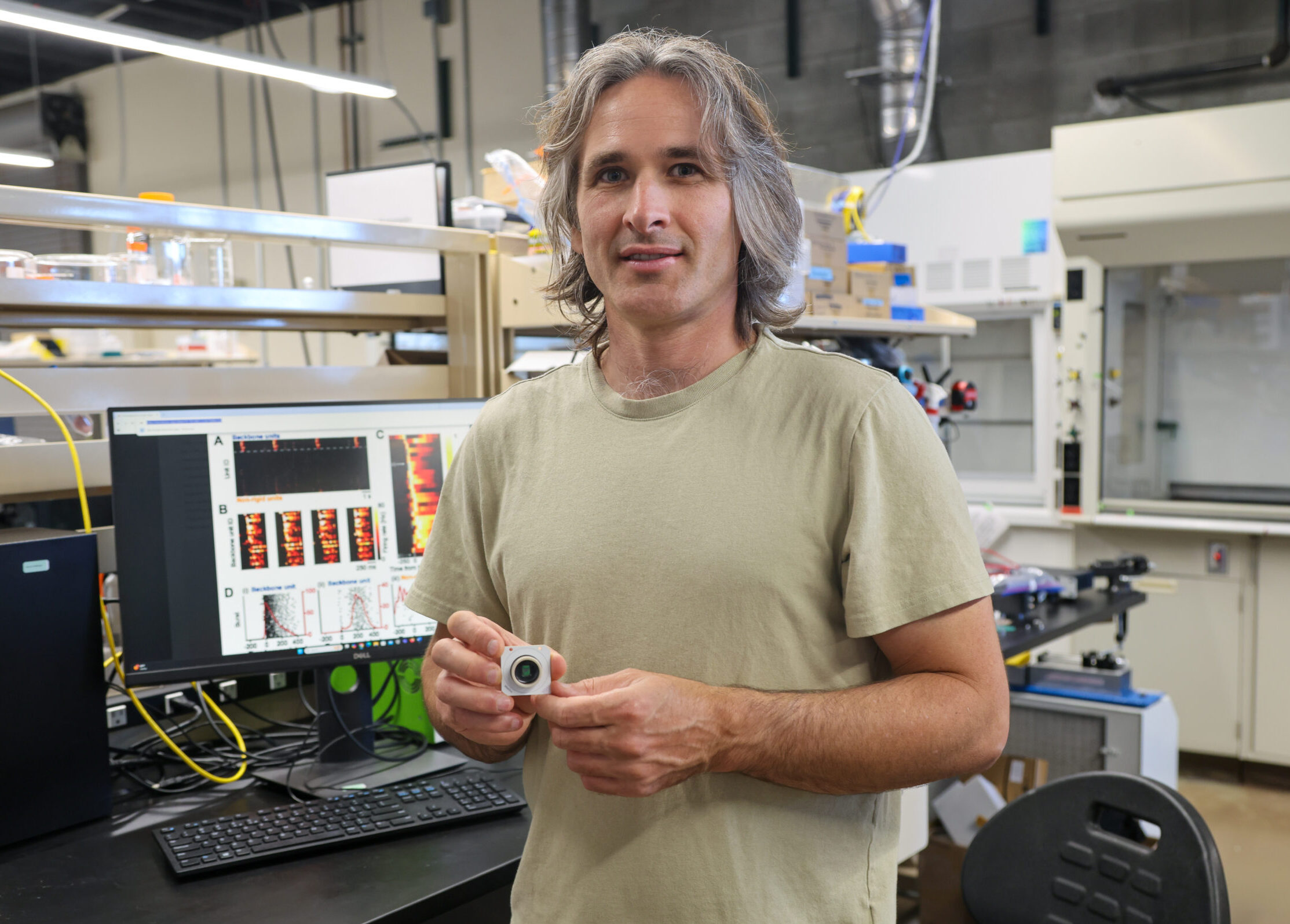 Tal Sharf holds up a small specialized chip in his lab