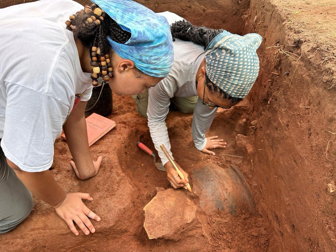 Maddy Aubey (UCLA) and Dominique Blount (Howard University) excavating a medieval trash pit.