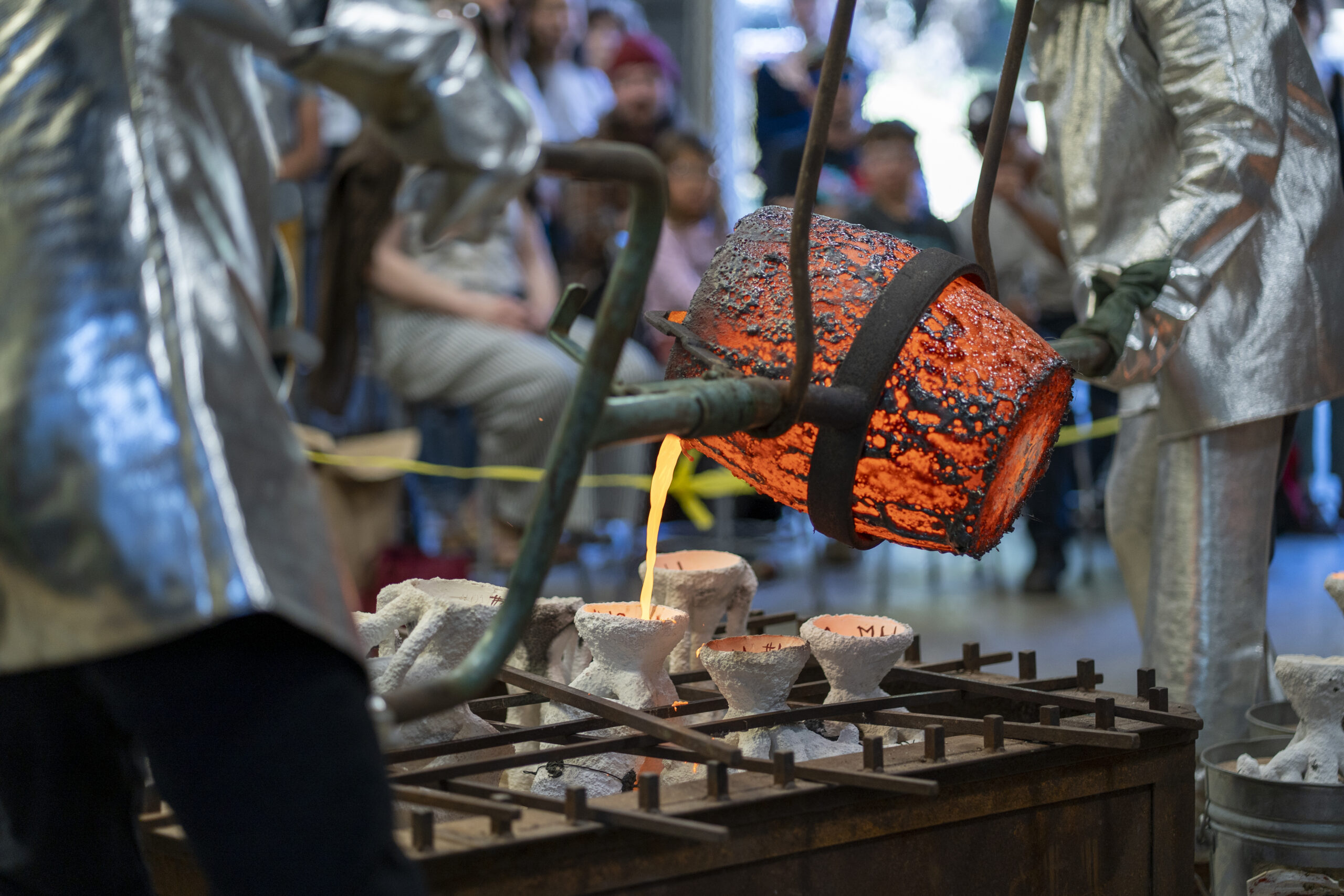 Sean Monaghan pouring molten bronze at the foundry for the annual bronze pour.