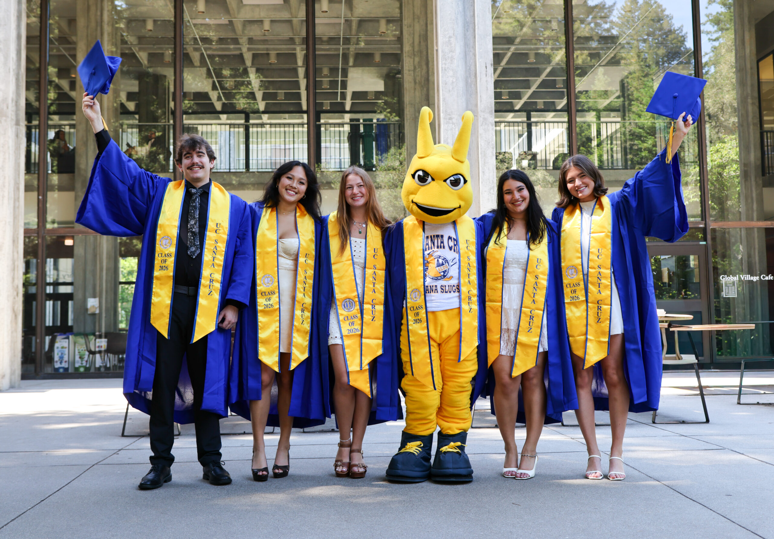 Happy grads with Sammy in front of McHenry library