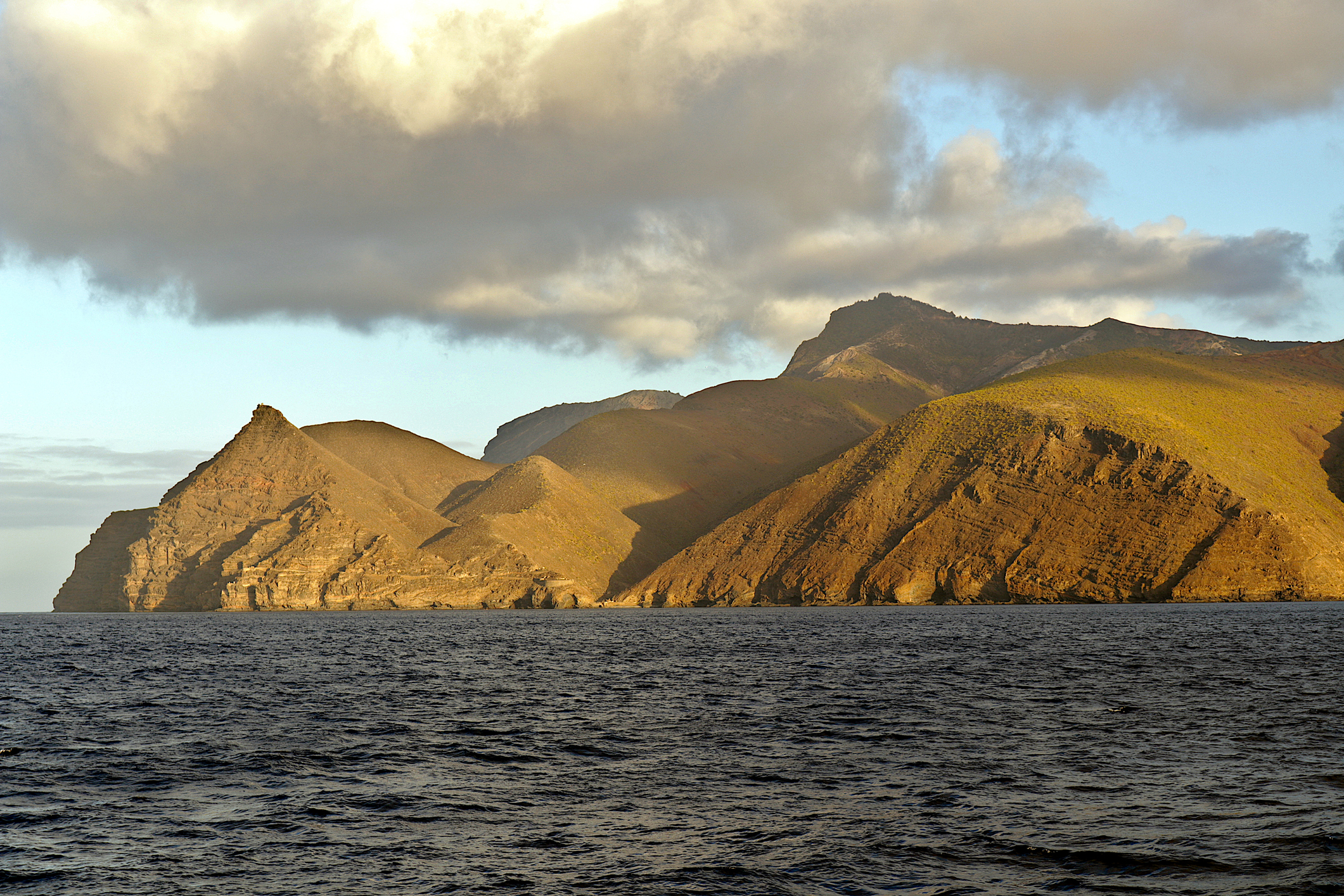 The green, mountainous coastline of Saint Helena Island, as seen from the ocean.