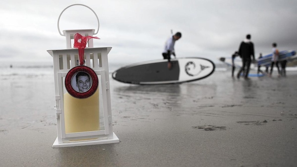 Locket-size portrait of Tim Vorenkamp attached to memorial item on a beach