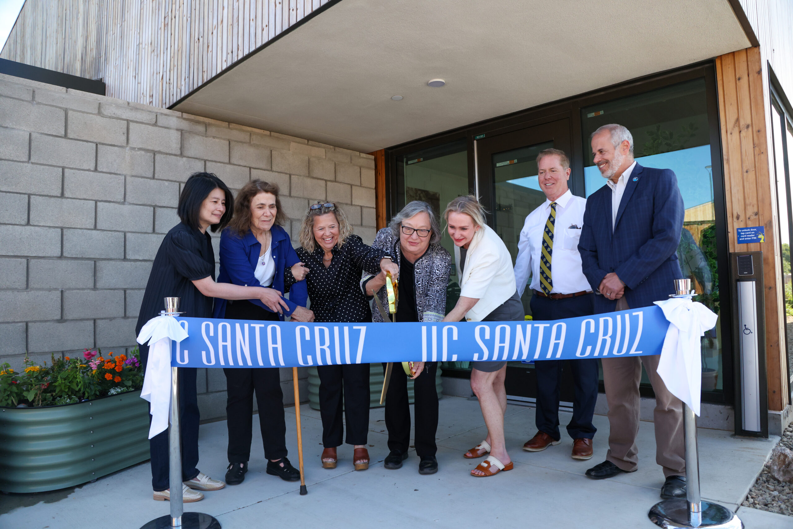 A group including Chancellor Larive, Laura Arroyo, Emili Willett, Dave Keller, and Catherine Cooper cut a ribbon in front of the Early Education Center